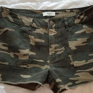 Camouflage distressed denim shorts.
